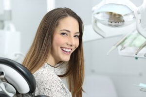 a young woman smiling in a dental chair